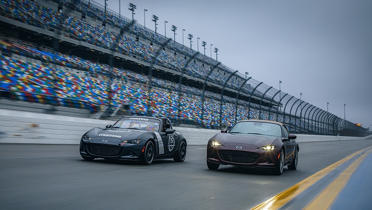 Mazda MX-5 Miatas Driving Side by Side on a Racetrack