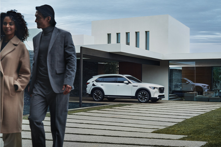 Mantenimiento de los autos eléctricos 101  –  Un Mazda CX-90 PHEV estacionado fuera de una casa