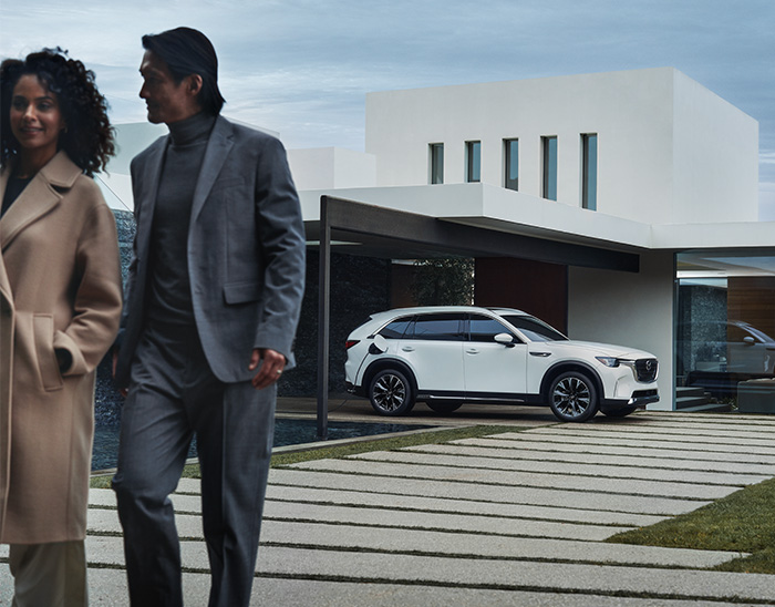 Mantenimiento de los autos eléctricos 101  –  Un Mazda CX-90 PHEV estacionado fuera de una casa