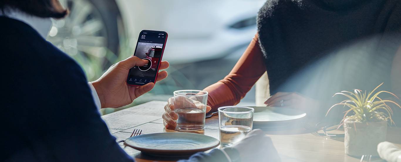 Person on phone using Mazda Connected Services