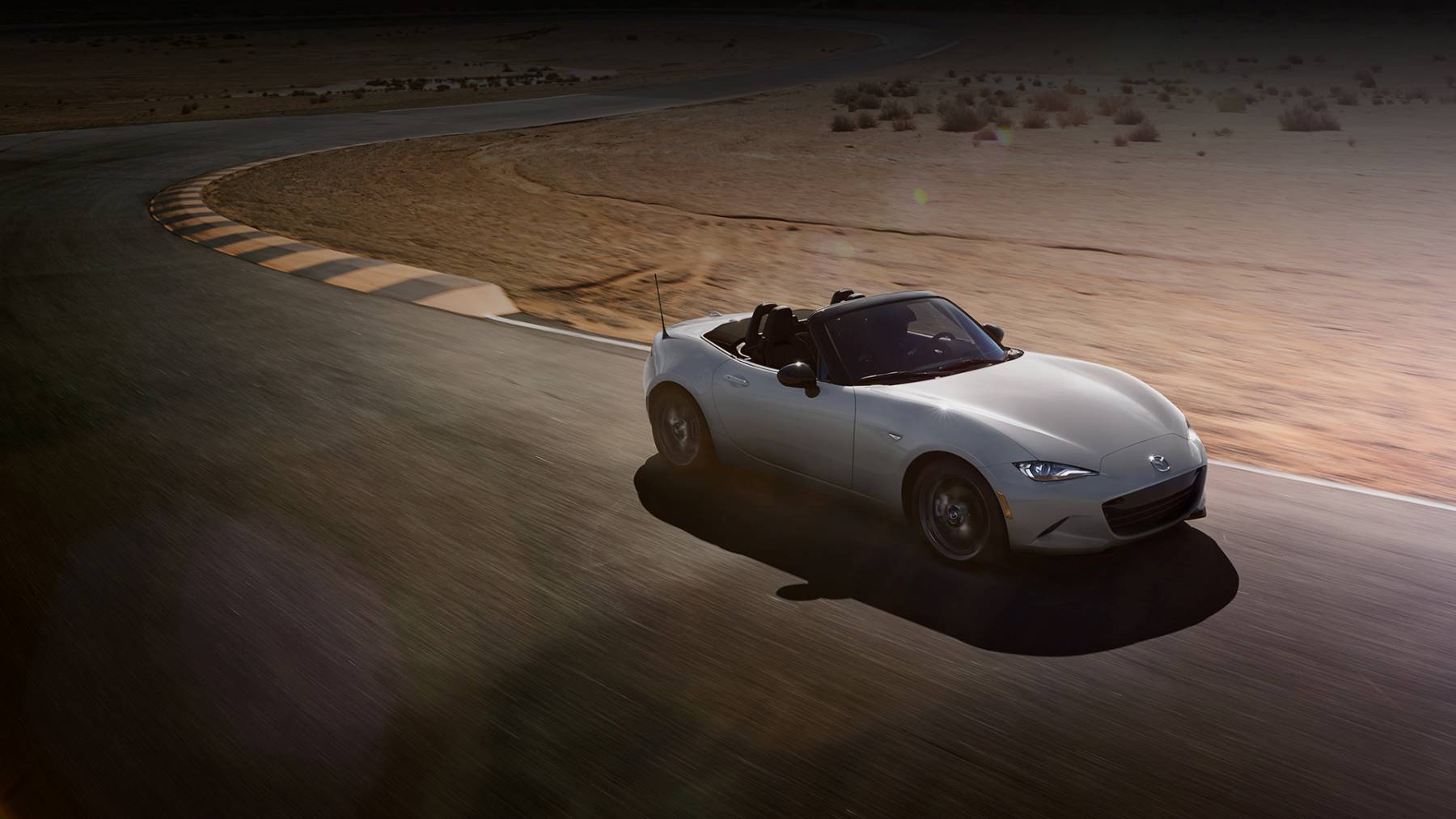 2024 Mazda Miata driving on race track. 